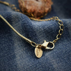 Close-up of gold chain lobster clasp with extension links and Lia Sophia tag, adjustable necklace length detail for handmade druzy quartz geode pendant, secure closure design for everyday wear boho western jewelry