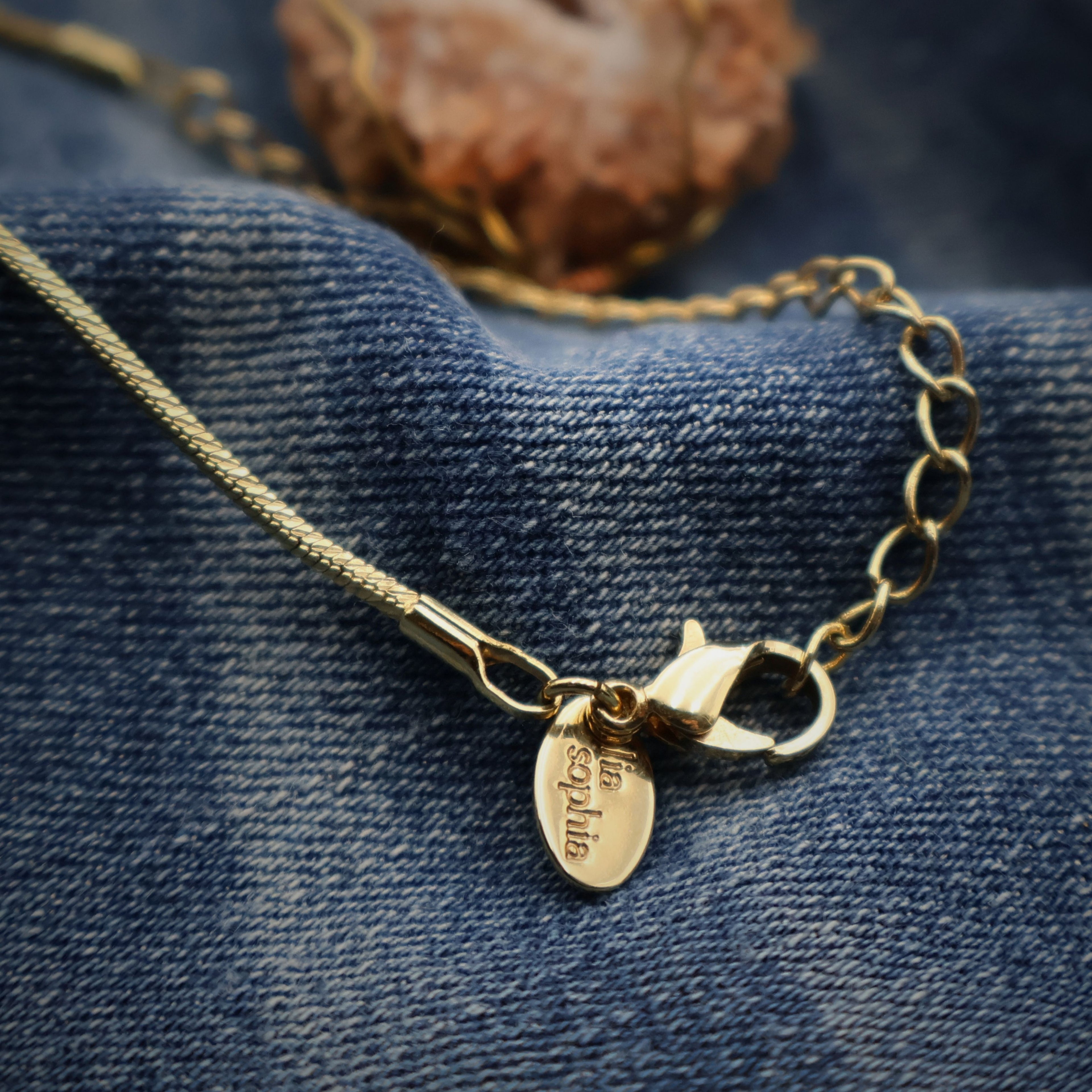 Close-up of gold chain lobster clasp with extension links and Lia Sophia tag, adjustable necklace length detail for handmade druzy quartz geode pendant, secure closure design for everyday wear boho western jewelry