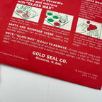Close-up of the red Christmas stencil package showing illustrated Glass Wax application instructions, the Gold Seal Company Bismarck address, and a 1969 copyright beside the Litho in U.S.A. marking. Creasing and small areas of wear appear along the bottom edge.