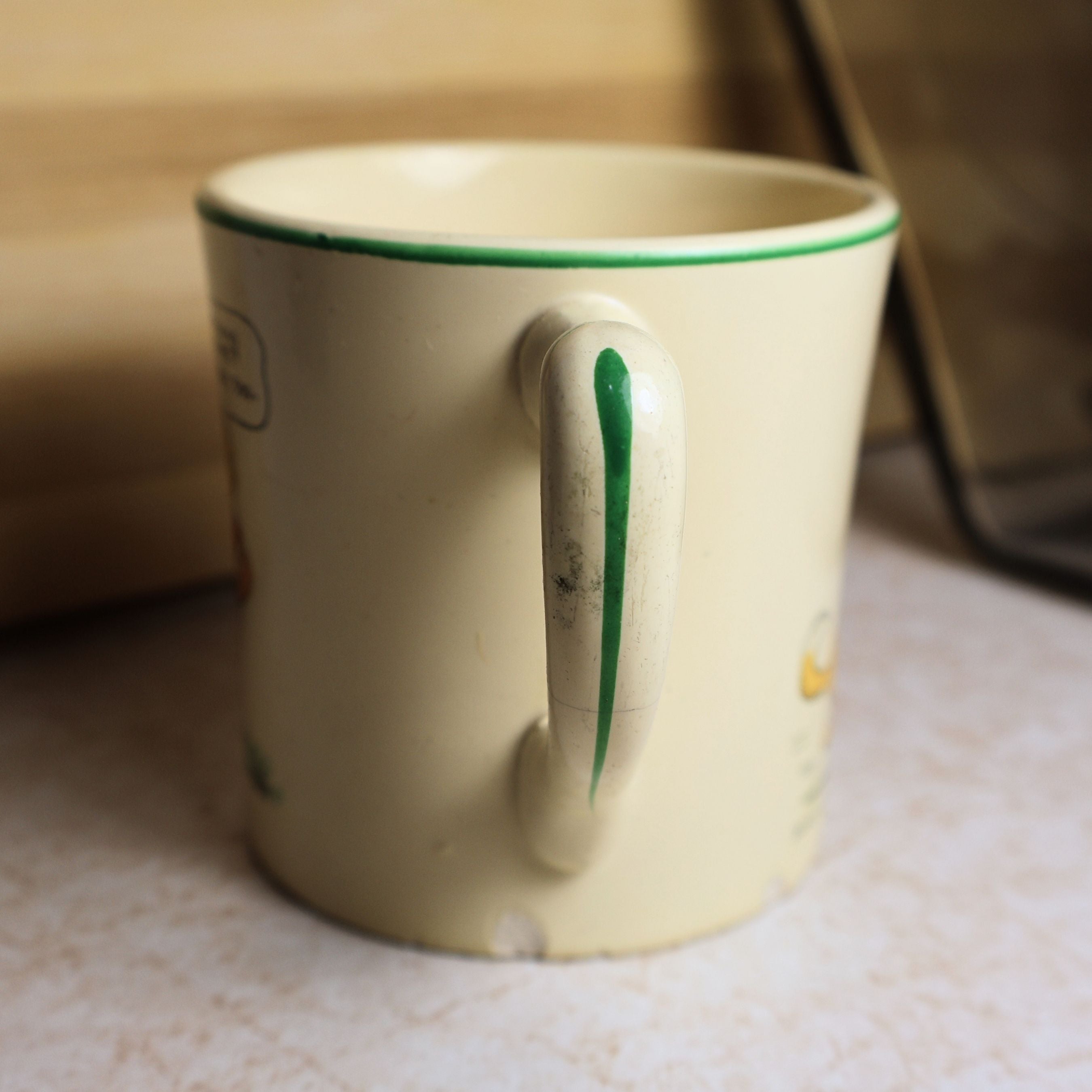 Side view highlighting the oversized handle and green accent stripe of the vintage ceramic Ovaltine coffee mug.