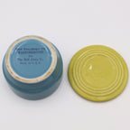 Flat lay of Hall China Westinghouse refrigerator dish base and lid showing underside stamp and vintage glaze finish.