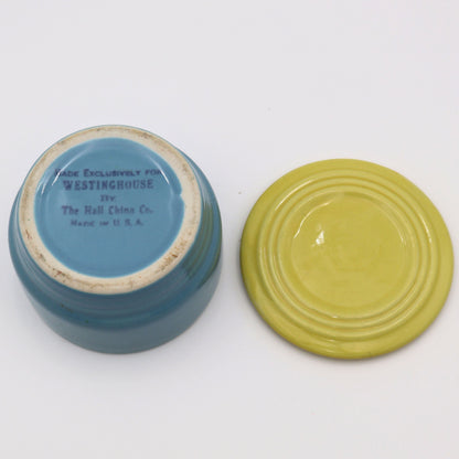 Flat lay of Hall China Westinghouse refrigerator dish base and lid showing underside stamp and vintage glaze finish.