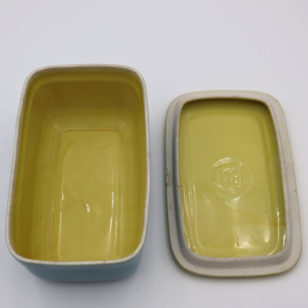Inside view of vintage Hall China Westinghouse refrigerator dish with embossed W on yellow lid.