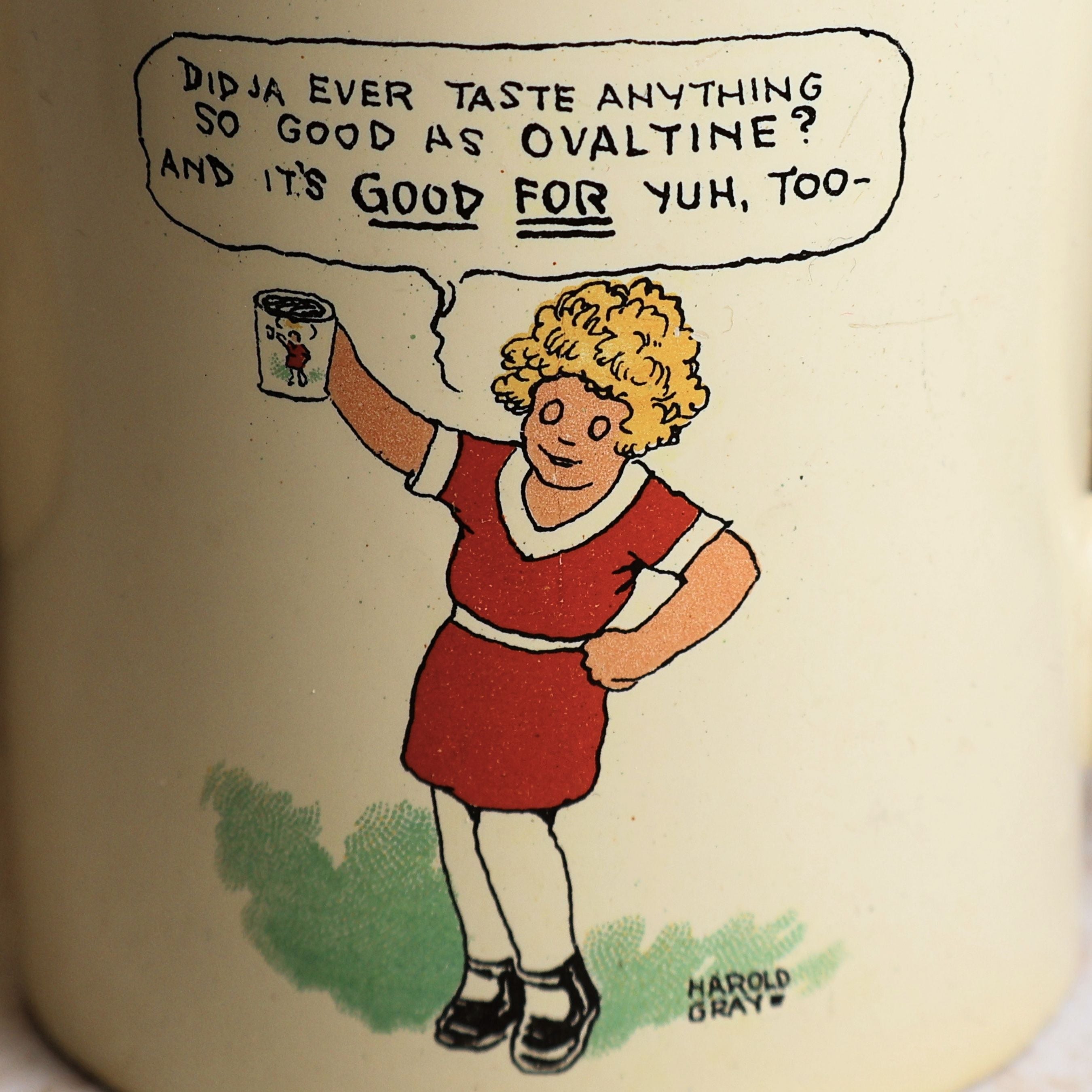 Close-up of the Harold Gray Ovaltine illustration showcasing the vintage advertising artwork and printed promotional slogan.