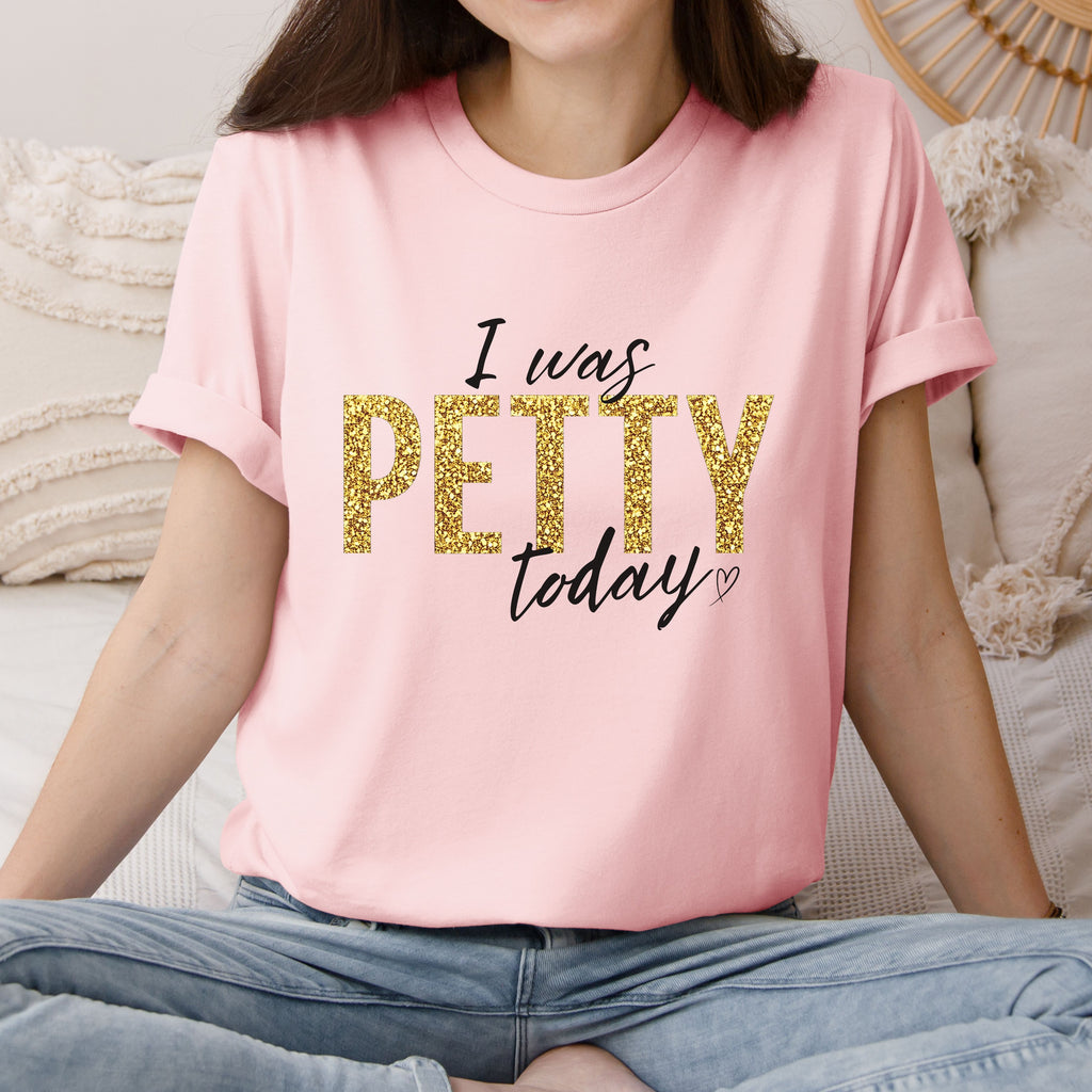 Woman wearing soft pink “I Was Petty Today” gold faux glitter shirt, feminine casual outfit, funny sarcastic graphic tee for women, trendy boutique apparel