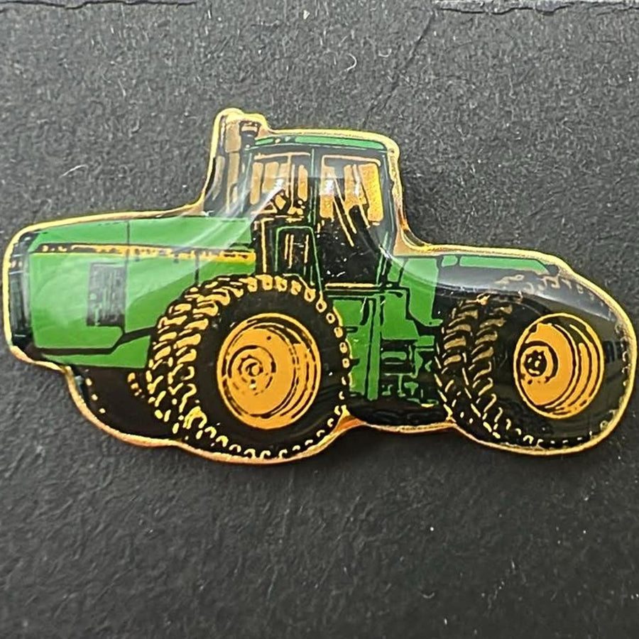 Detailed front view of John Deere tractor enamel pin highlighting green and yellow tractor design with gold tone outline, classic farm equipment style, vintage lapel pin for farmers, tractor enthusiasts, and western inspired outfits
