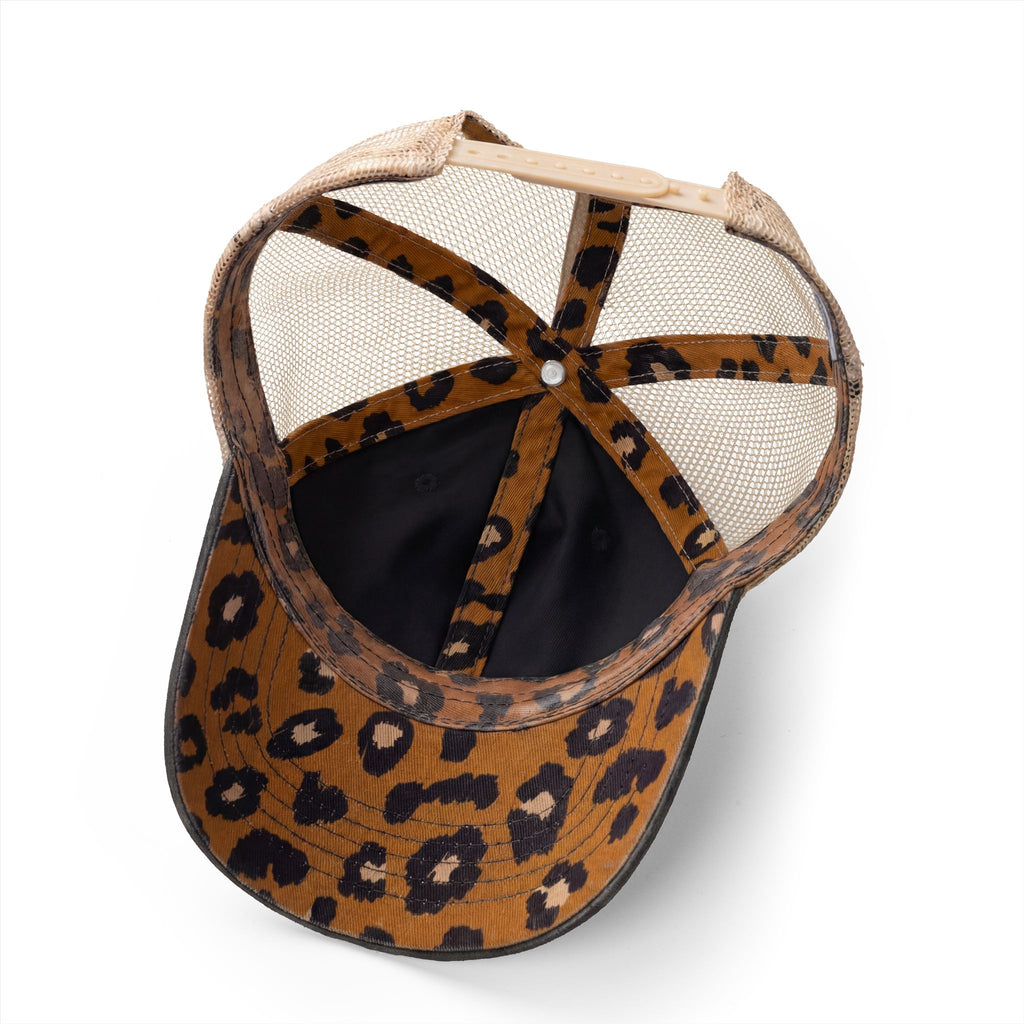 Interior view of washed black women’s trucker hat showing leopard print underbrim and coordinating seam tape detail