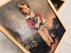 Angled close-up of the boy-with-dog reproduction print in its cream frame. The child wears a red jacket and pale collar, with flowers and a tipped basket nearby. Reflected light across the raised surface makes the print’s decorative texture clearly visible.