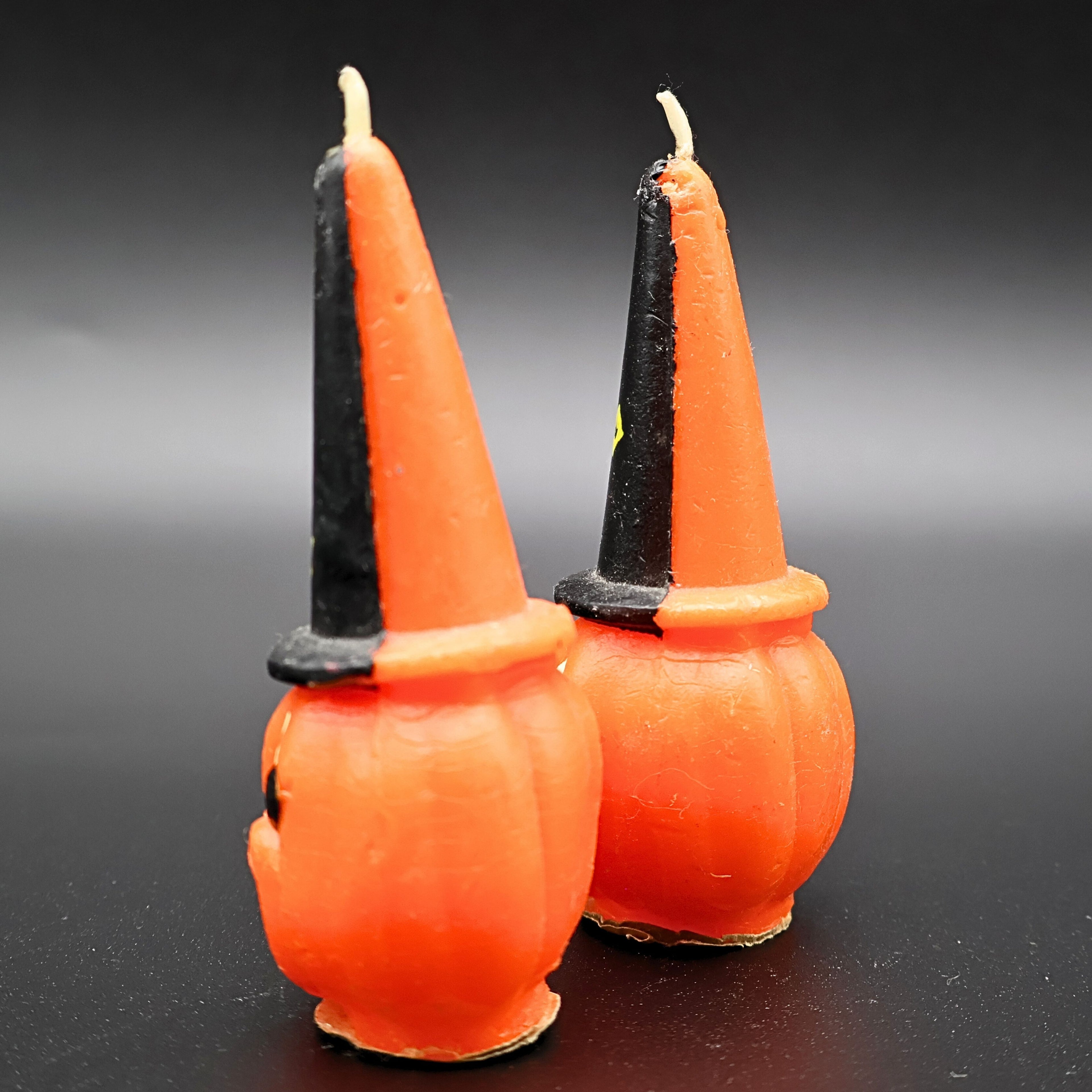 Pair of vintage Gurley Halloween candles displayed together with bright orange pumpkins and witch hats