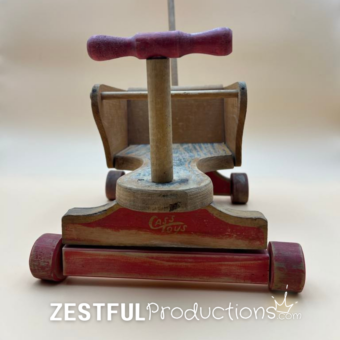 Detail of aged wood and original paint on vintage doll push stroller