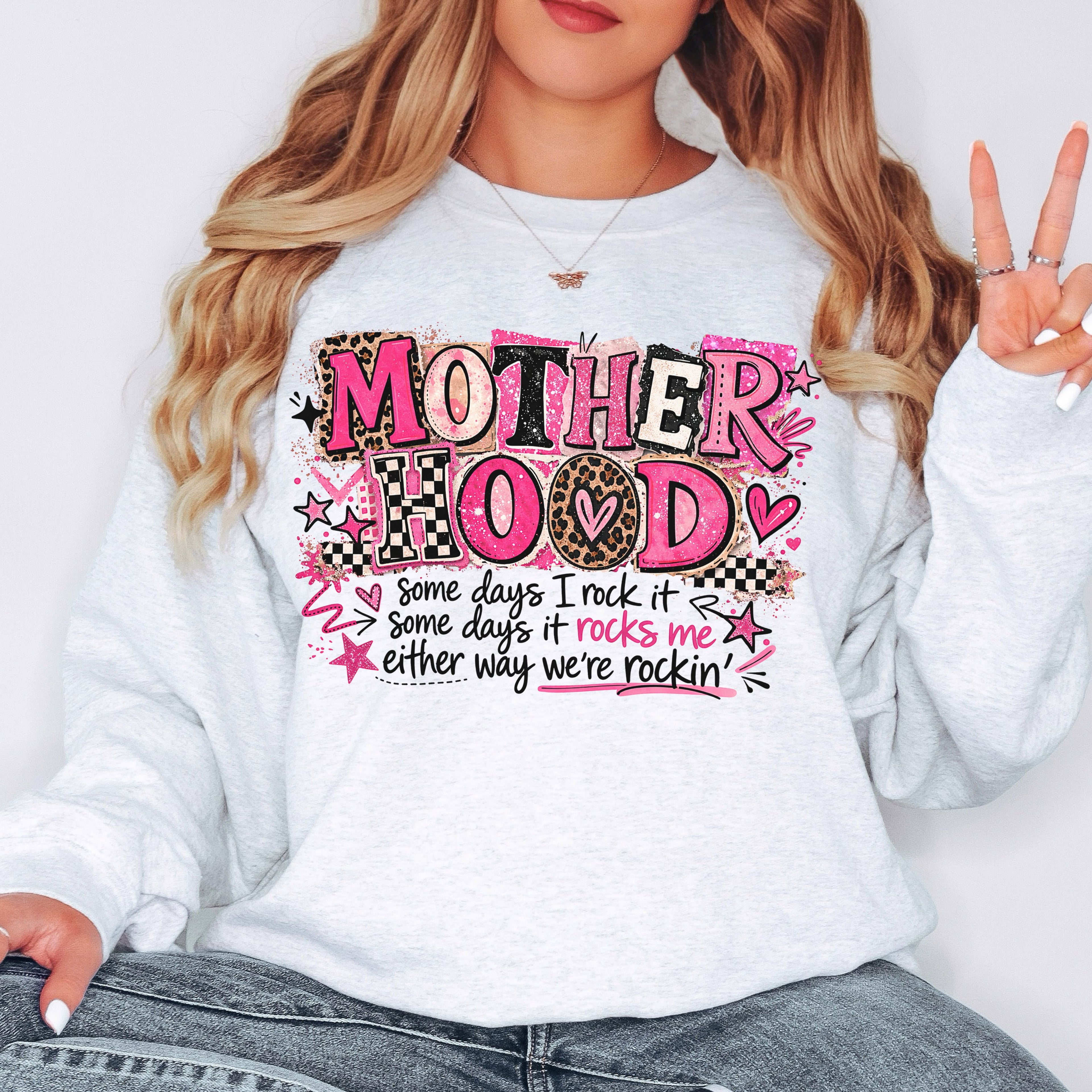 Trendy white Mother Hood graphic sweatshirt with pink leopard print lettering modeled in casual oversized boutique mom outfit.