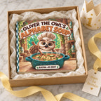 Oliver the Owl’s Alphabet Soup board book nestled in tissue paper inside a square gift box with yellow ribbon, a birthday crown and a Happy First Birthday tag.