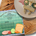Oliver’s owl-shaped sandwich recipe from The Culinary Pro, with illustrated ingredients and instructions displayed beside a plate holding a bread sandwich with cucumber eyes and cheese details.