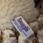 Detailed close-up of the original Snuggle tag showing Lever Brothers branding on an authentic 1986 plush mascot. Original tags enhance collector appeal for vintage advertising enthusiasts and lovers of nostalgic household memorabilia.