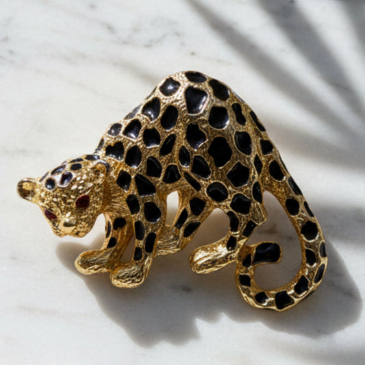 Vintage Park Lane cheetah brooch pin in gold-tone metal with black enamel spots and red rhinestone eyes