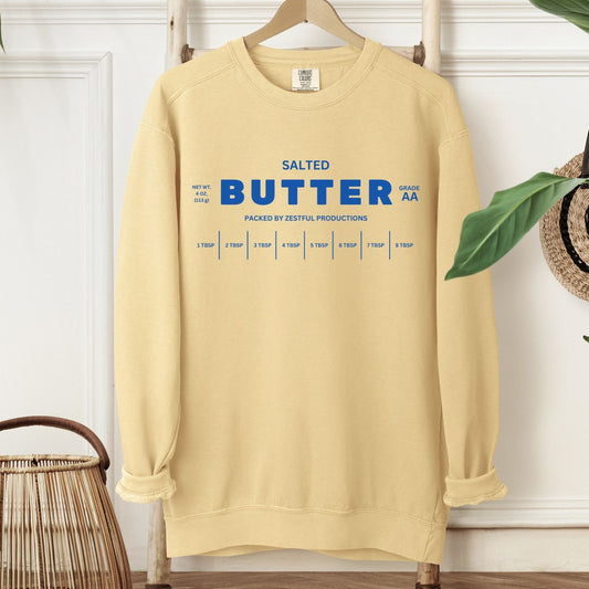 Personalized butter sweatshirt displayed on hanger in home setting. Soft yellow crewneck with clean graphic design.