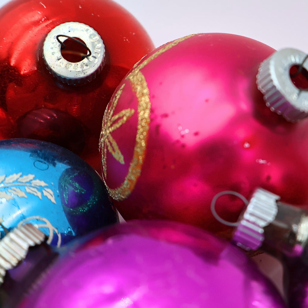 Macro closeup of pink blue and silver mercury glass Christmas ornaments with reflective vintage Shiny Brite style details