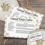 Printed oatmeal raisin cookie recipe cards arranged with vintage Golden Wheat dishes and wheat stalks on a dark wooden table. The coordinated 4 x 6 inch cards bring nostalgic charm to a collected kitchen or family recipe box.