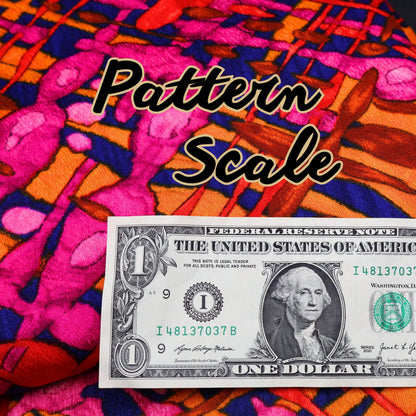 Close-up of vintage curtain fabric showing pattern scale next to dollar bill for size reference.
