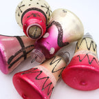 Flat lay of vintage atomic bell ornaments with pink black and cream mercury glass finishes and retro holiday styling