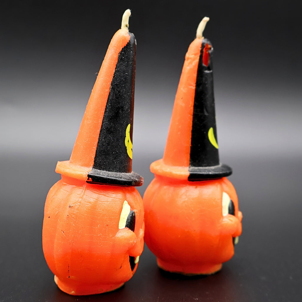 Side profile of vintage Gurley pumpkin candles with tall black witch hats, mid century Halloween decor