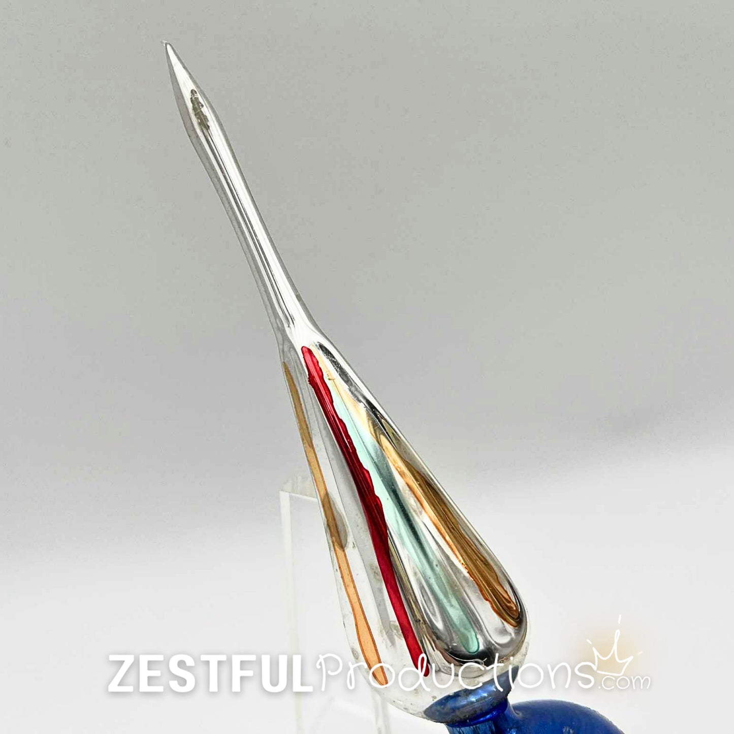 Side profile of vintage handblown mercury glass Christmas tree topper featuring elongated finial point with red, gold, and green accents in authentic 1960s retro holiday style.