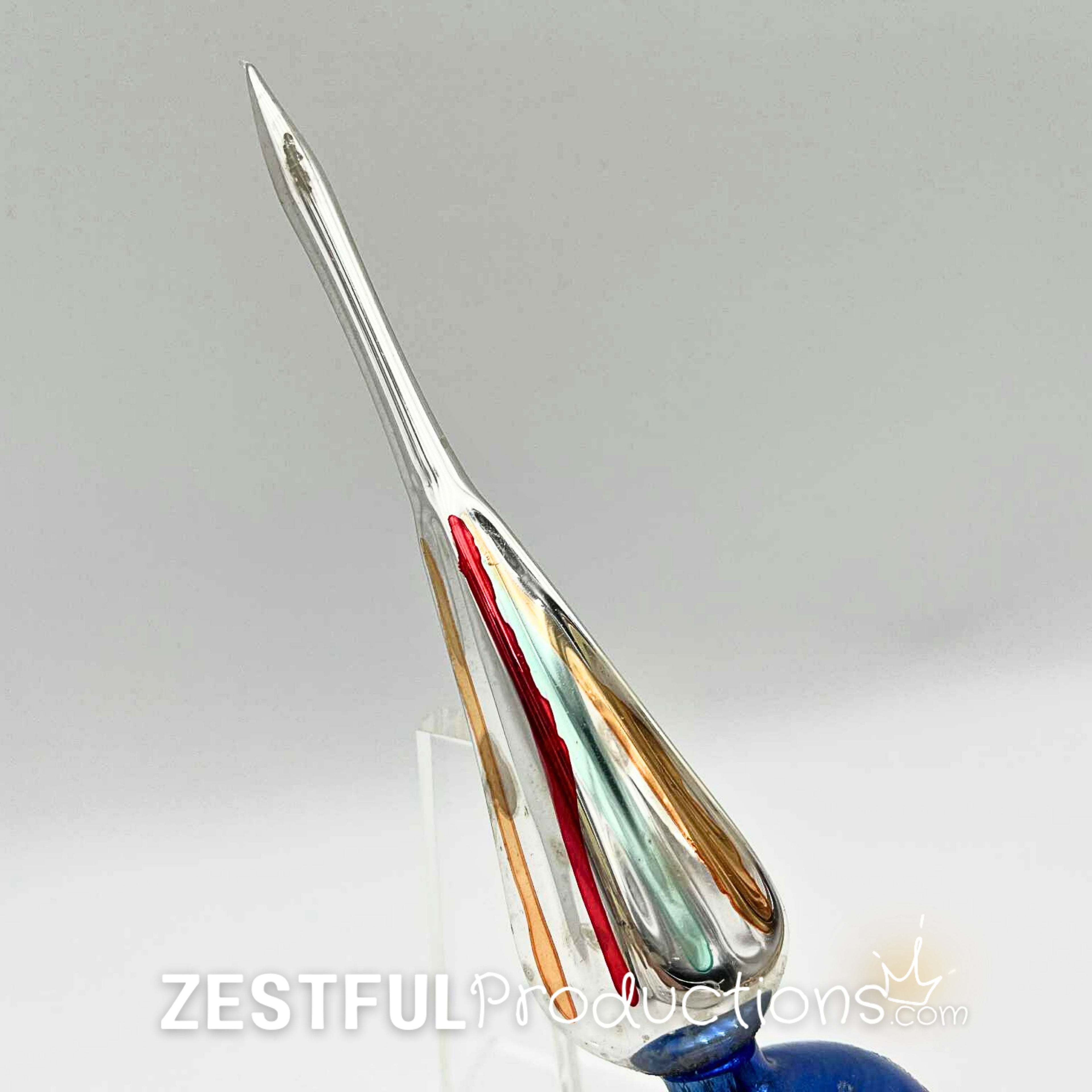 Side profile of vintage handblown mercury glass Christmas tree topper featuring elongated finial point with red, gold, and green accents in authentic 1960s retro holiday style.