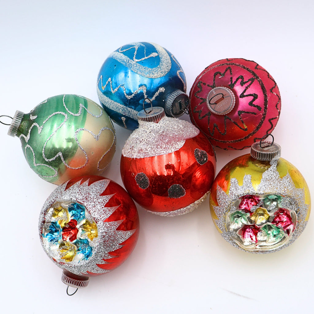 Vintage reflector indent ornaments featuring atomic era Christmas styling and jewel tone mercury glass decoration