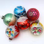Vintage reflector indent ornaments featuring atomic era Christmas styling and jewel tone mercury glass decoration
