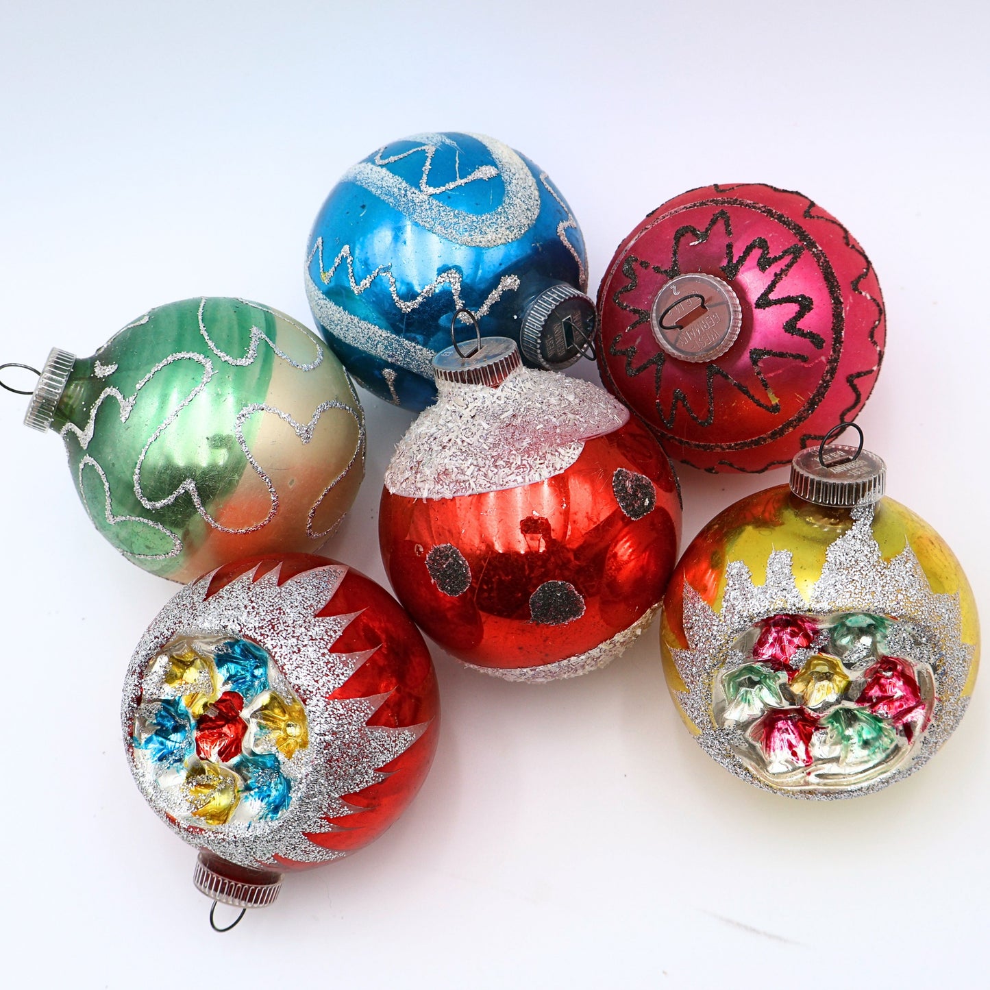 Vintage reflector indent ornaments featuring atomic era Christmas styling and jewel tone mercury glass decoration