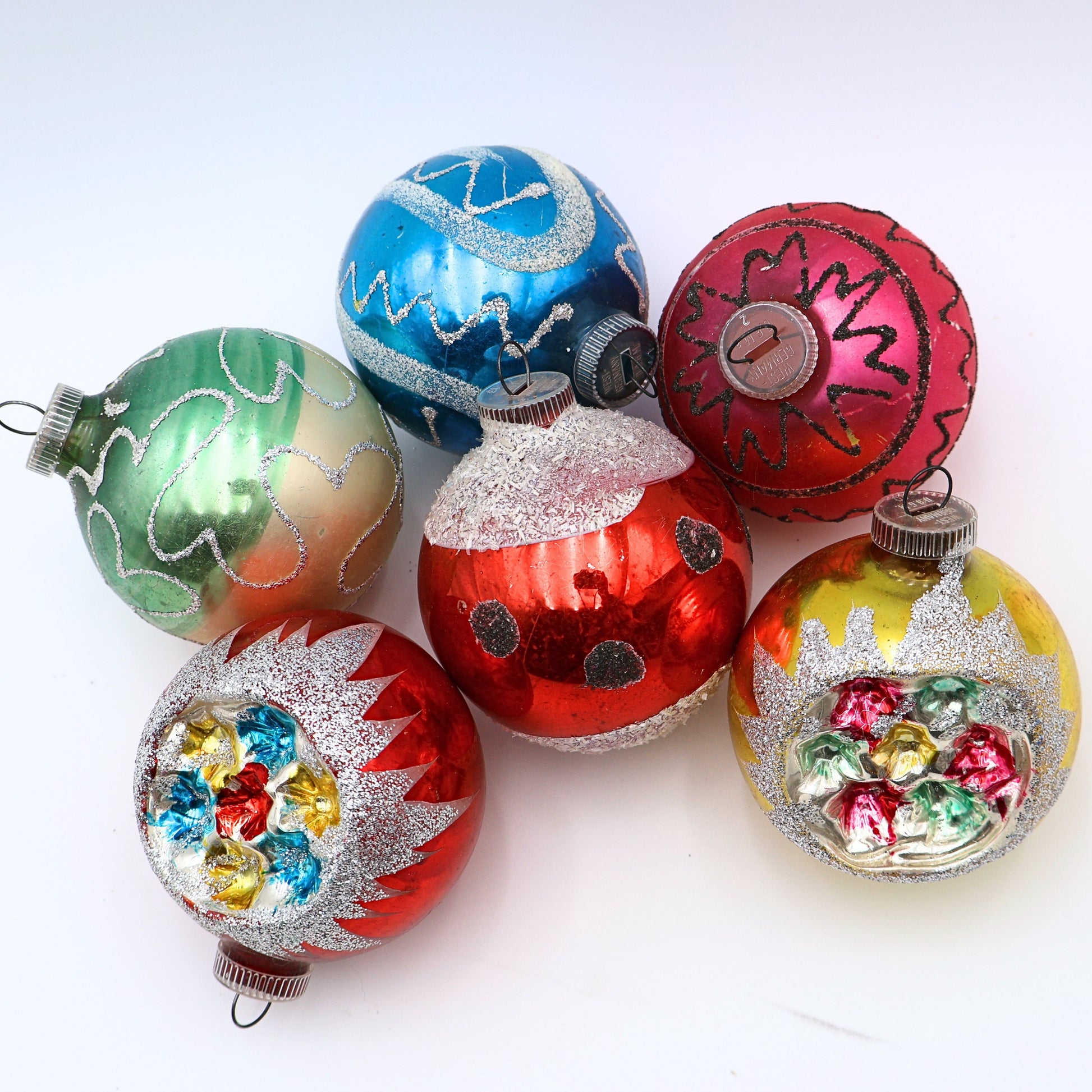 Vintage reflector indent ornaments featuring atomic era Christmas styling and jewel tone mercury glass decoration