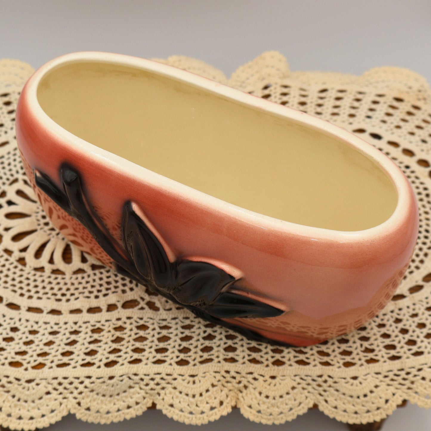 Angled top view of vintage Royal Copley oval planter with cream interior and pink exterior glaze.