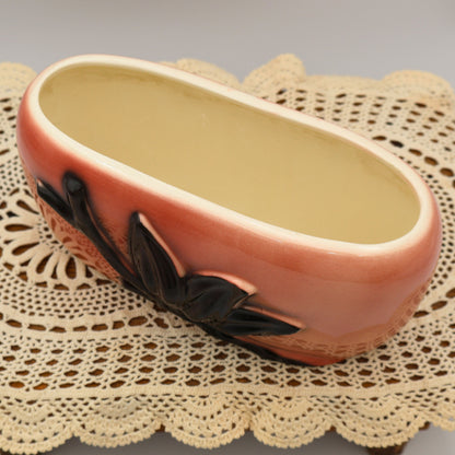 Angled top view of vintage Royal Copley oval planter with cream interior and pink exterior glaze.