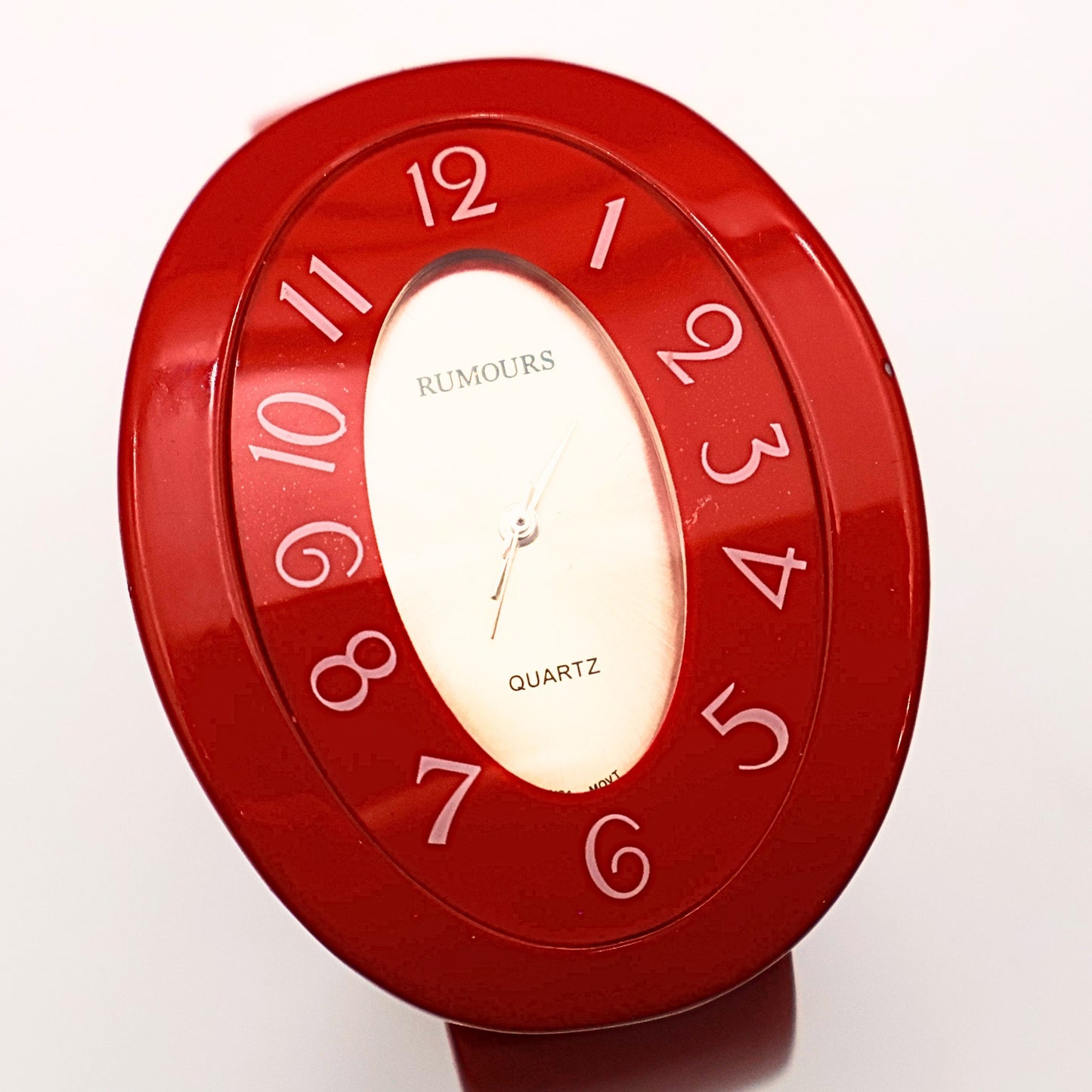 Rumours 29978 red cuff watch face showing stylized numbers and quartz movement dial, vintage bracelet watch with bold retro design and glossy finish