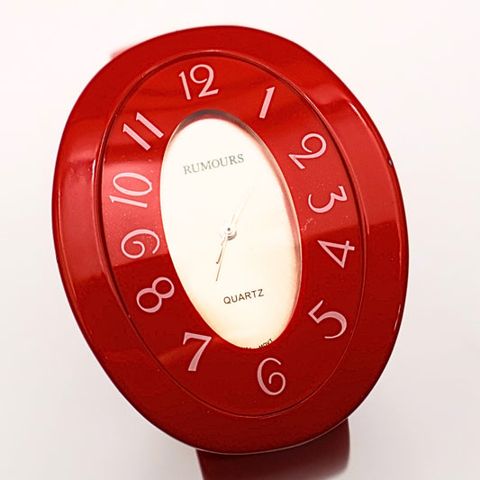 Rumours 29978 red cuff watch face showing stylized numbers and quartz movement dial, vintage bracelet watch with bold retro design and glossy finish