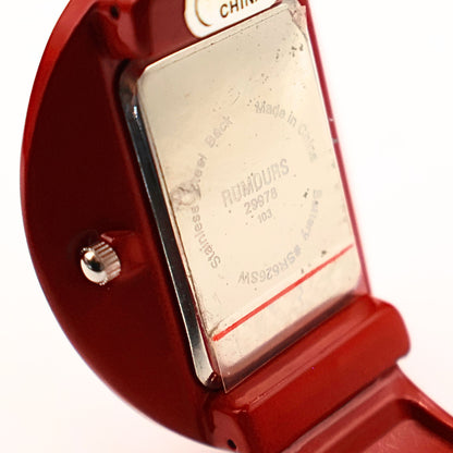 Close-up detail of Rumours 29978 watch stamp on back case, vintage red cuff watch with model number and branding visible on metal plate