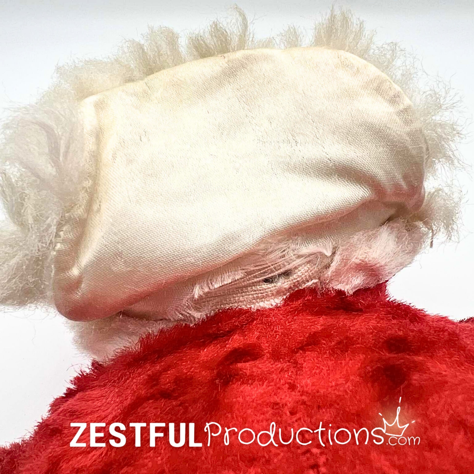 Detailed underside fabric and stitching view of vintage Rushton style Santa Claus plush doll with fluffy beard and plush red suit. Antique 1950s Christmas collectible showing authentic construction details for collectors.