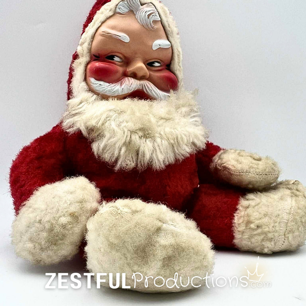 Side angle of vintage Santa Claus plush doll in Rushton style with rosy cheeks, red plush suit, and fluffy white trim. Mid century modern Christmas collectible ideal for retro holiday decor and nostalgic seasonal displays.