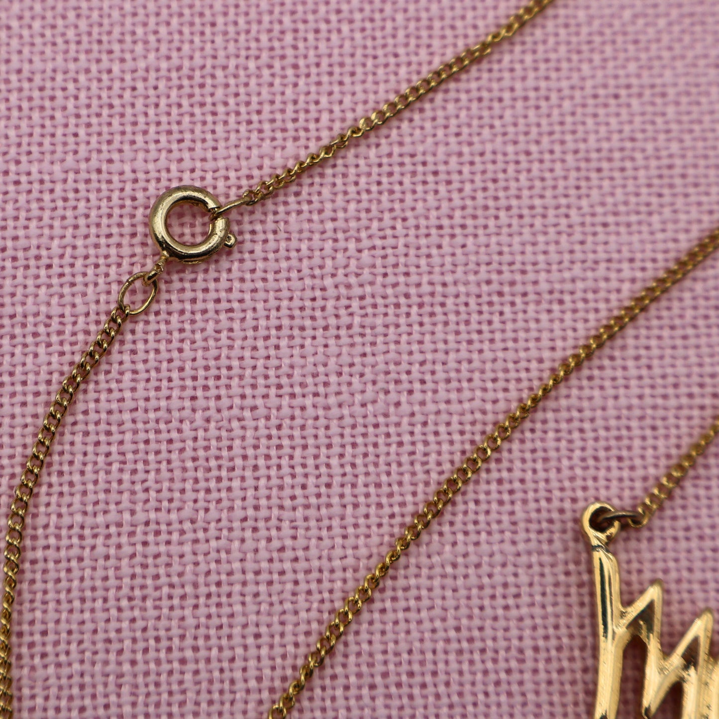 Close-up of spring ring clasp and gold tone chain on vintage Sarah Coventry Mary Kay necklace.