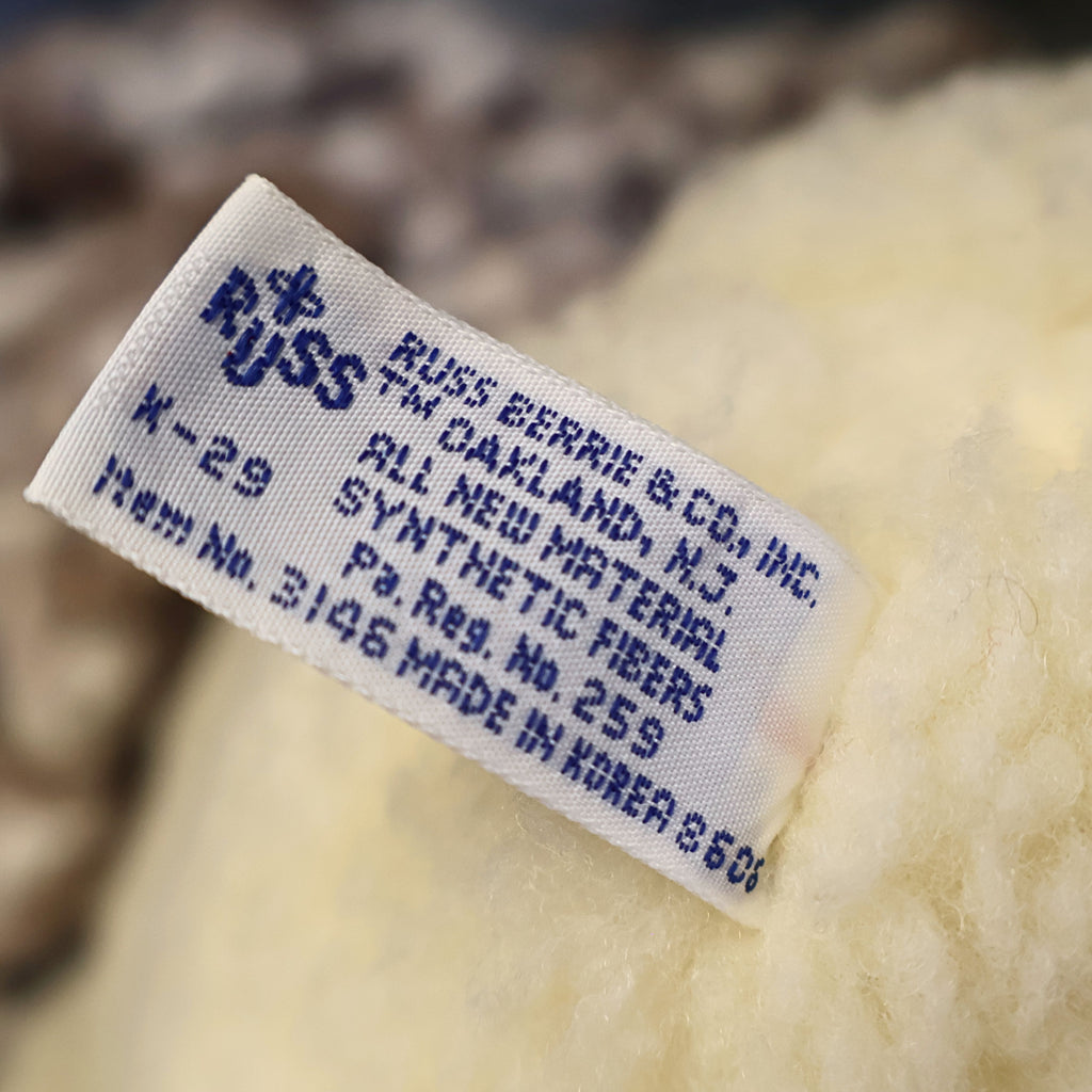 Close-up photograph of the original woven Snuggle tag attached to a vintage 1986 Lever Brothers plush bear. The tag helps verify authenticity and adds collector appeal for buyers seeking original advertising mascot memorabilia from the 1980s.