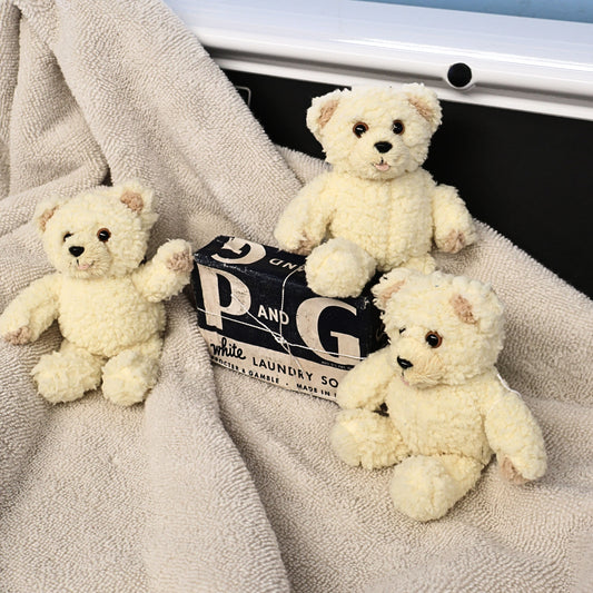 Three vintage Snuggle by GUND plush mascots arranged around a vintage Procter & Gamble laundry soap package. The cozy display highlights their charming expressions and fluffy cream fur, ideal for collectors of advertising memorabilia, GUND plush, and nostalgic home decor.