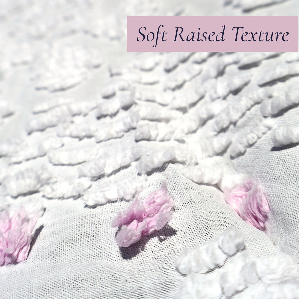 Macro photograph showing the luxuriously soft raised chenille texture on a vintage white bedspread with lavender floral accents. Beautiful for farmhouse decor, cottage bedrooms, heirloom bedding collections, vintage textiles, and romantic interior decorating.