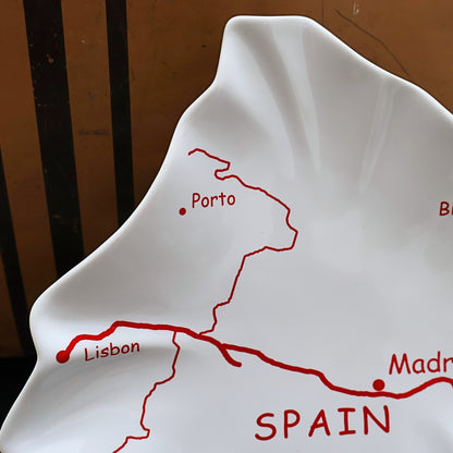 Closeup of vintage Spain map ceramic tray featuring Lisbon Porto and travel route graphics, glossy white Mediterranean serving platter, Spain shaped European souvenir dish, collectible ceramic catchall tray with red typography