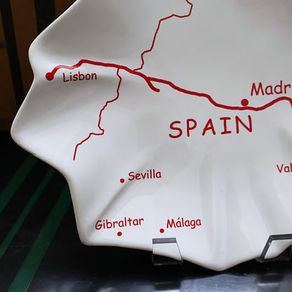 Closeup detail of vintage Spain map ceramic serving platter with bold red typography and city graphics, glossy white Spain shaped tapas tray, Mediterranean travel decor, European souvenir serving dish for entertaining
