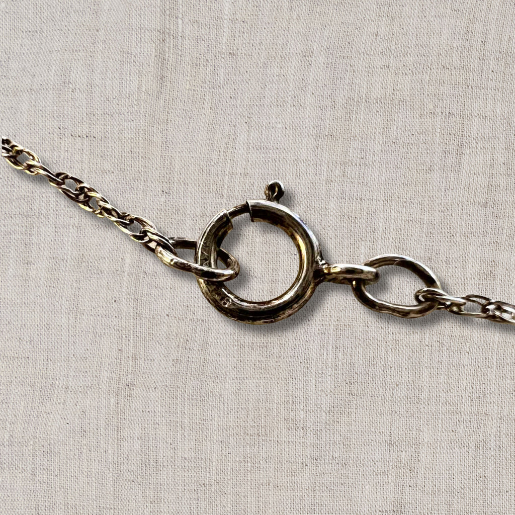 close up of sterling silver spring ring clasp on vintage necklace chain, secure closure detail for 18 inch coin pendant necklace, authentic silver chain hardware showing craftsmanship and wear consistent with vintage jewelry condition