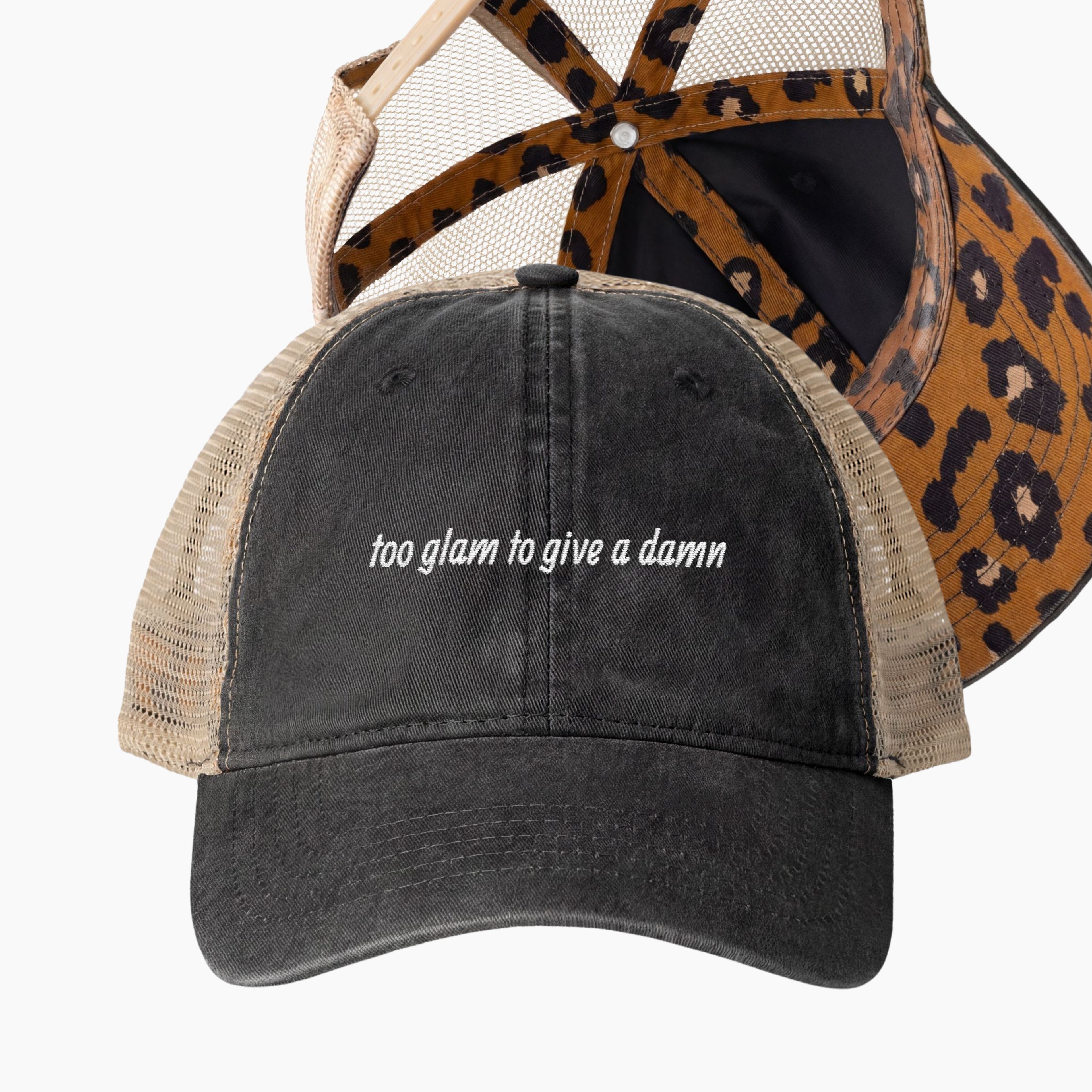 Washed black mesh back trucker hat with too glam to give a damn embroidered phrase and ponytail opening