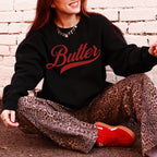 Black unsalted butter script crewneck sweatshirt with bold red lettering. Vintage inspired graphic pullover styled with casual outfit. Cozy unisex sweatshirt perfect for butter lovers, farmhouse fashion, and everyday wear.