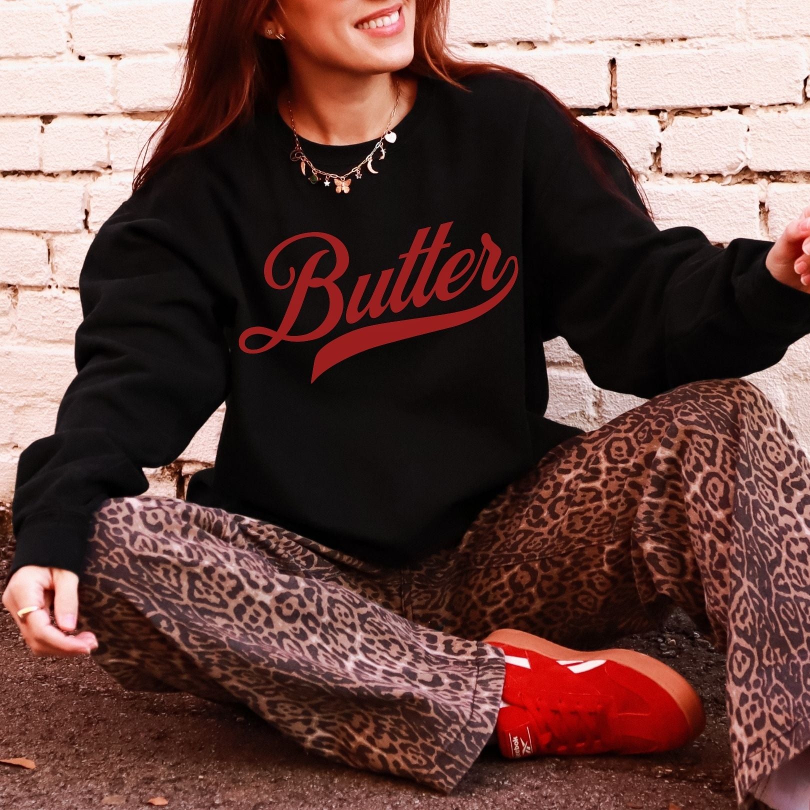 Black unsalted butter script crewneck sweatshirt with bold red lettering. Vintage inspired graphic pullover styled with casual outfit. Cozy unisex sweatshirt perfect for butter lovers, farmhouse fashion, and everyday wear.