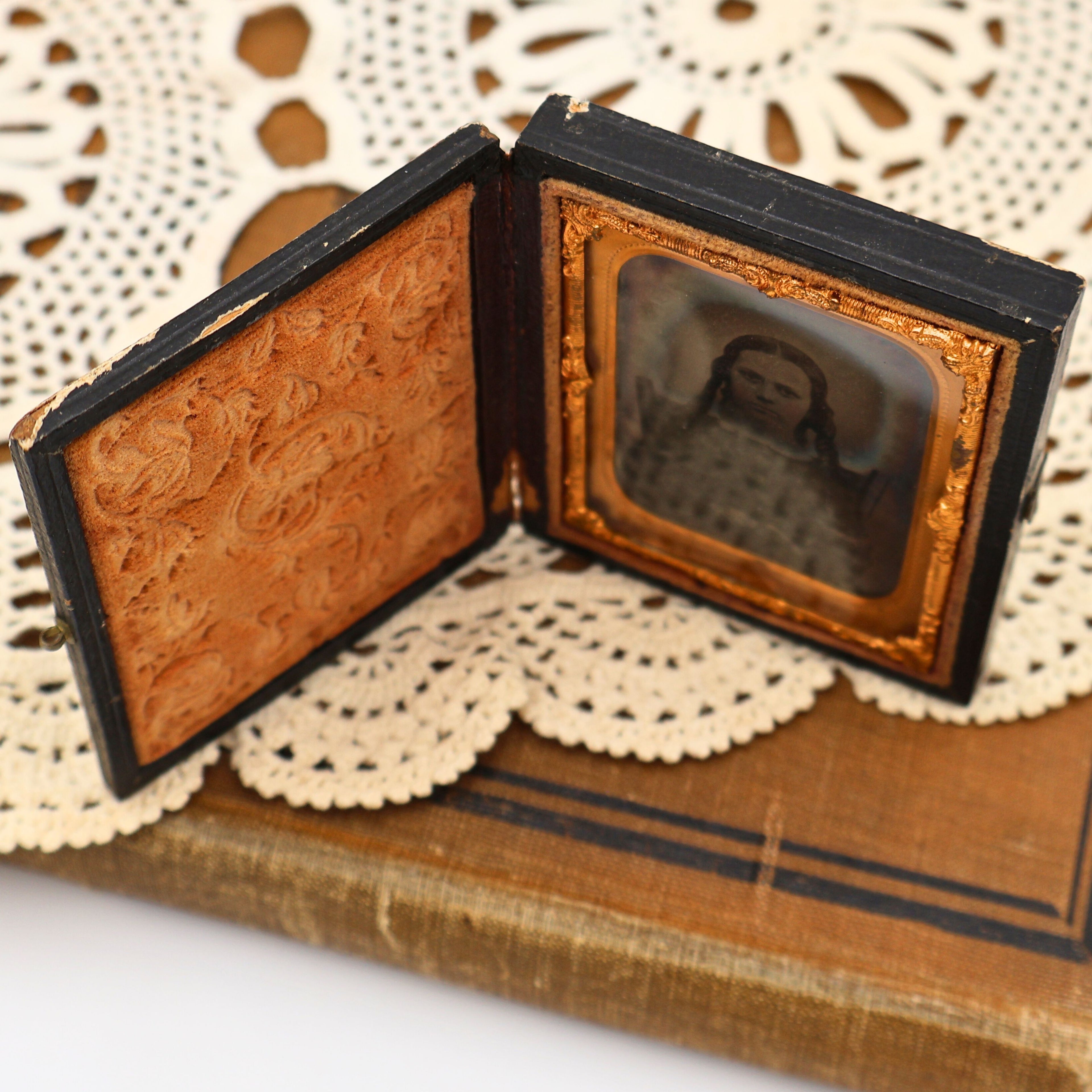 Interior view of the antique thermoplastic Union case highlighting the richly embossed velvet panel, ornate gilt brass mat, and preserved Civil War era ambrotype portrait. Fine decorative details illustrate why these nineteenth-century photography cases remain collectible today.