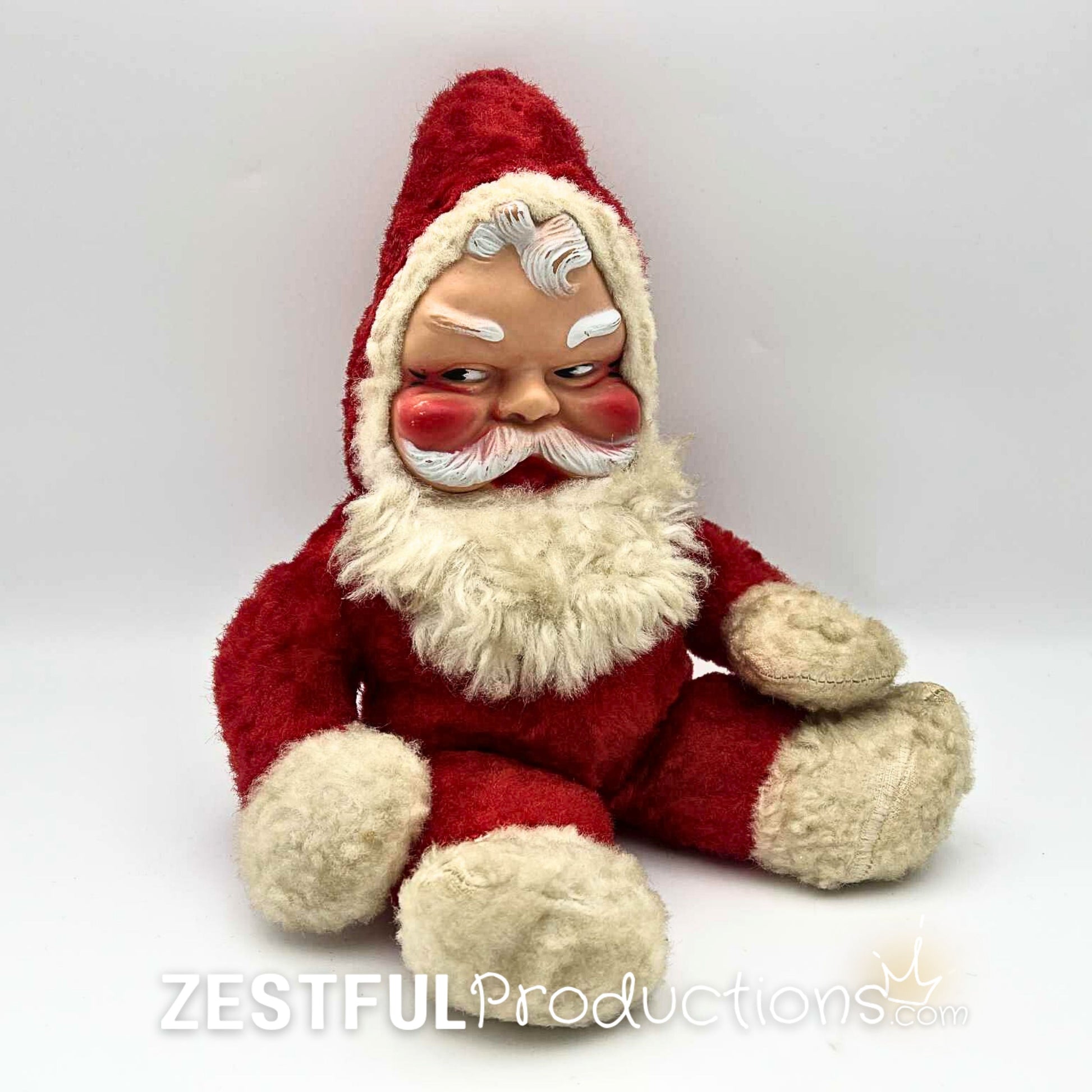 Vintage 1950s Rushton style Santa Claus plush doll collectible sitting upright with molded face, red suit, fluffy white beard, and mid century Christmas charm for retro holiday decor and antique toy collectors.